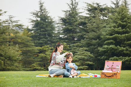 玩游戏的婴儿母女坐在草地上玩游戏背景