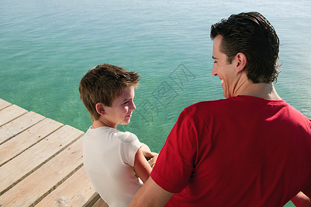 父亲和儿子在海边的码头上图片