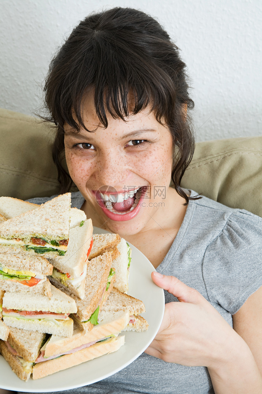 拿着一堆三明治的女人图片