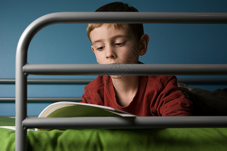 男孩在床上看书背景图片
