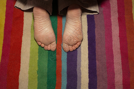 孩子的脚在条纹地毯上图片