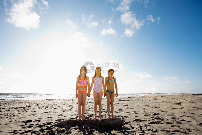 站在海滩上的女孩们手牵着手图片