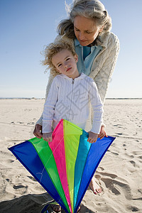 奶奶和孙女在海滩上玩风筝图片