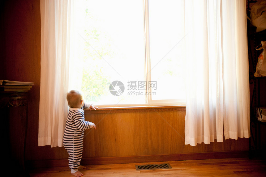 从窗户向外看的小男孩图片