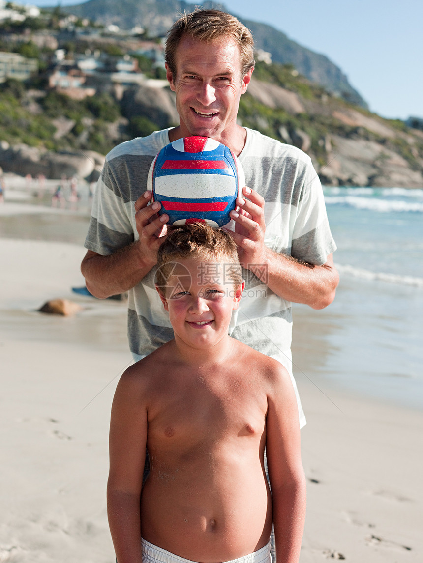 爸爸和儿子在沙滩上玩球图片