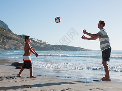 玩排球父子俩在海滩上打球背景