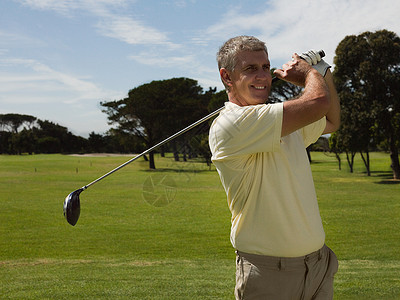 在高尔夫球场上打高尔夫的人图片
