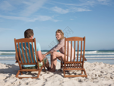 海滩上躺椅上的一对夫妇图片