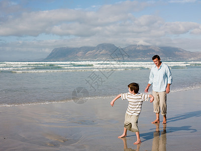 父子俩在海里扔石头背景图片