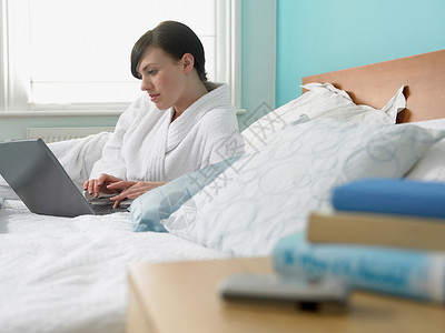 女人在床上用笔记本电脑图片