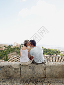 坐在墙头上接吻的情侣图片