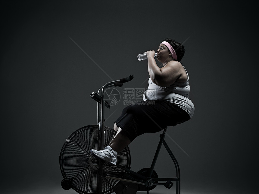 骑健身车的超重妇女图片