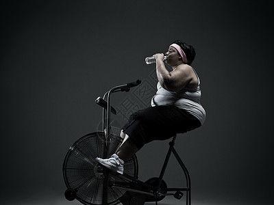 骑健身车的超重妇女图片