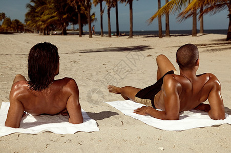 沙滩上日光浴在沙滩上晒太阳的男人背景