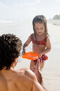在海滩上玩耍的父亲和女儿图片