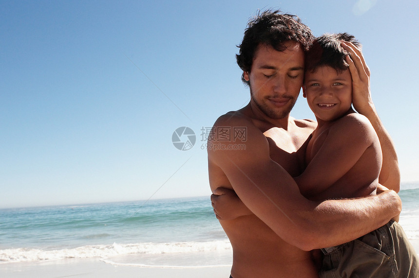 父亲在海滩上抱着儿子图片
