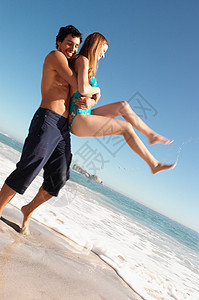 男人在海滩上抱着女人背景图片
