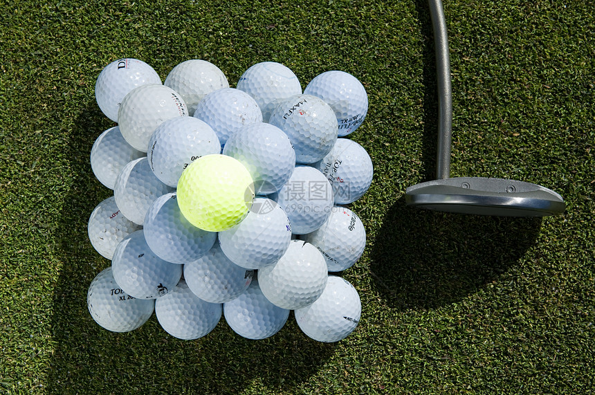 一堆高尔夫球和一个高尔夫球杆图片