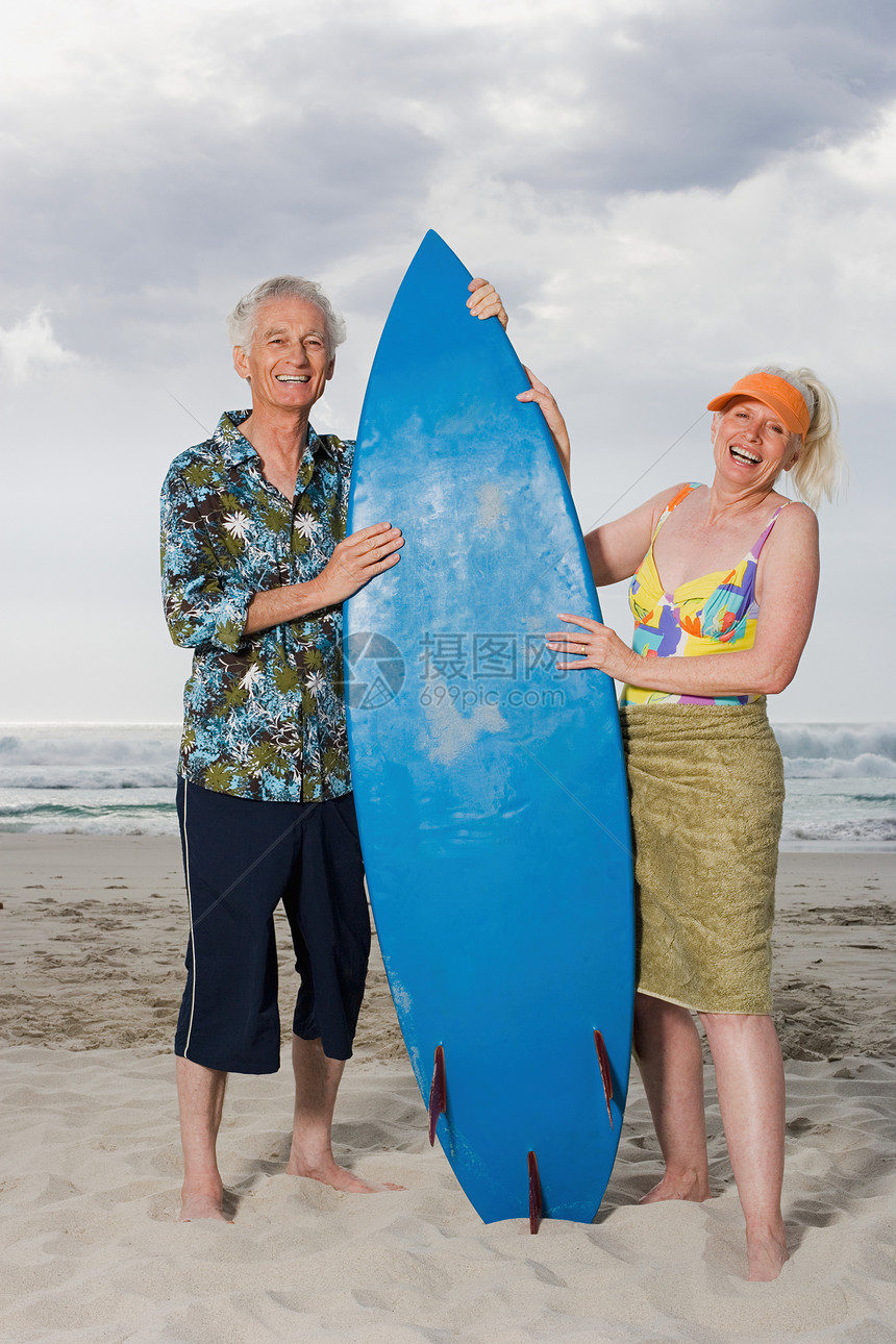 拿着冲浪板的老年夫妇图片