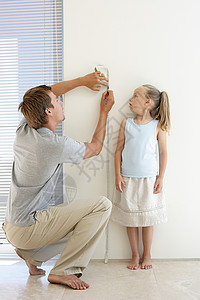 扶墙呕吐男人父亲测量女儿的身高背景