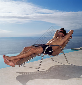 在泳池边放松的男人图片
