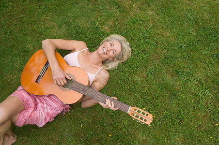躺在草地上弹吉他的女人图片