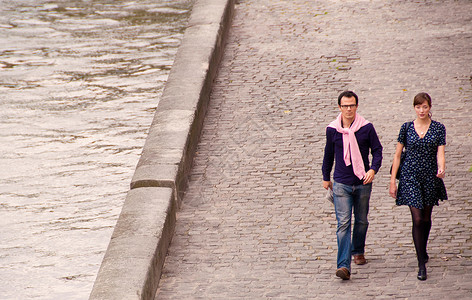 一对夫妇走在巴黎塞纳河边背景