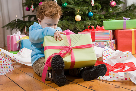 男孩拿着礼物男孩打开圣诞礼物背景