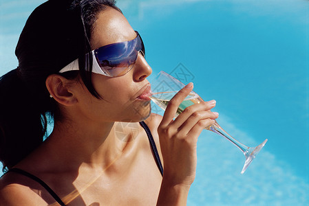 在泳池边喝香槟的女人图片
