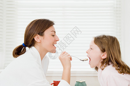 喂女儿吃早餐的母亲图片