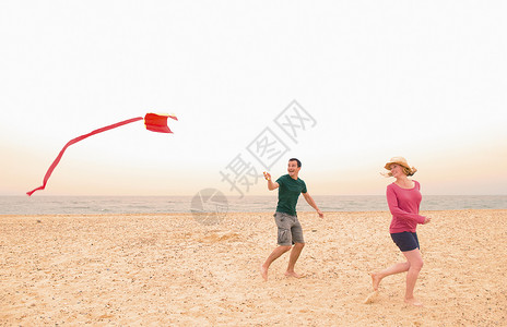 海滩上放风筝的夫妻图片