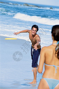 在海滩上玩飞盘的夫妻图片