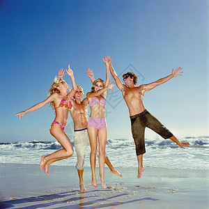 海滩上跳跃的年轻人图片