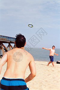 男孩们在海滩上玩飞盘图片