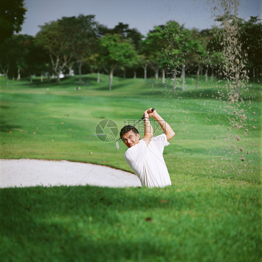沙坑旁的高尔夫球手图片