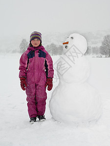 站在雪人旁边的女孩图片