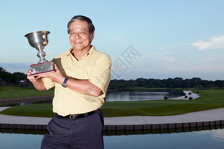 拿奖杯的男高尔夫球手图片
