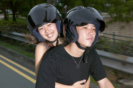 年轻的亚洲夫妇骑着轻便摩托车图片