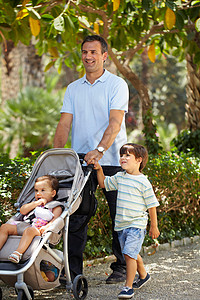 父亲和两个孩子在公园里图片