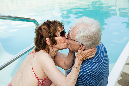老年夫妇在游泳池旁接吻图片