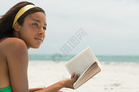 海滩上看书的女人图片
