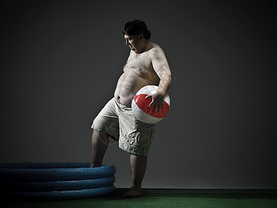 一个沙滩球玩沙滩球和游泳池的男人背景