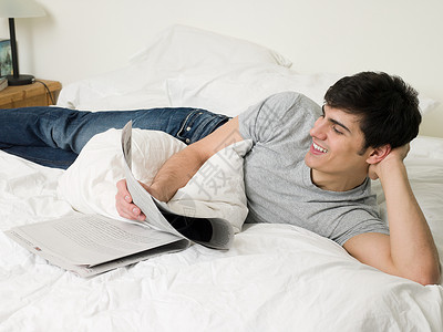 男人在床上看报纸背景图片