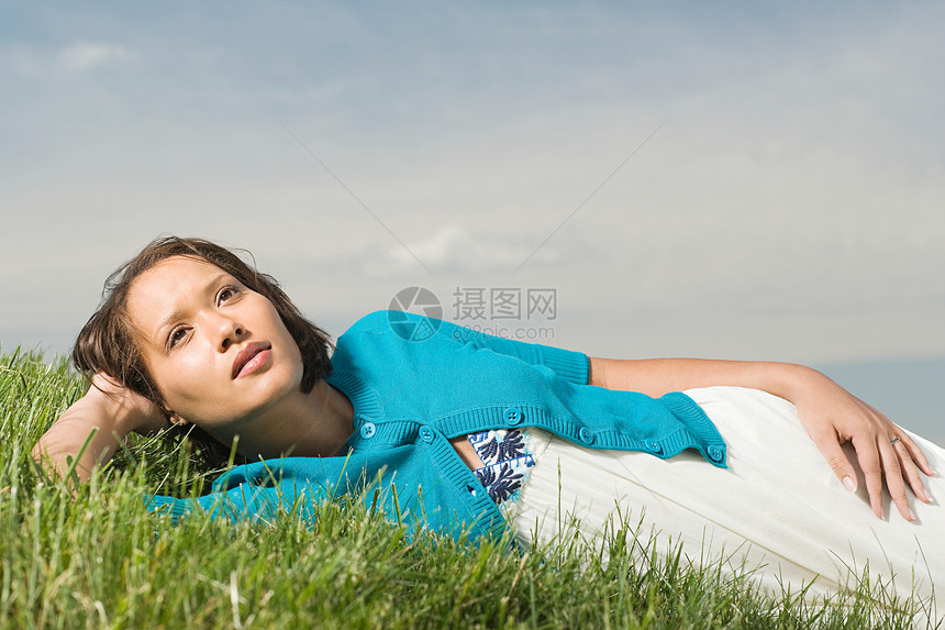 躺在草地上的年轻女子图片