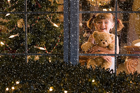 小女孩在窗户边上看雪背景图片