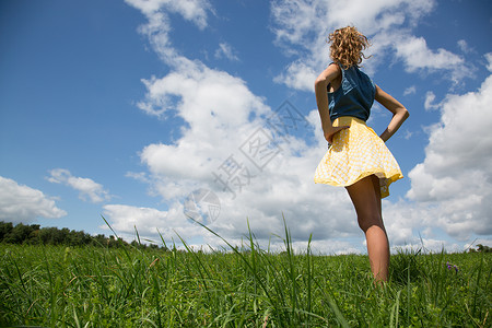 女孩双手叉腰站在田里看风景图片