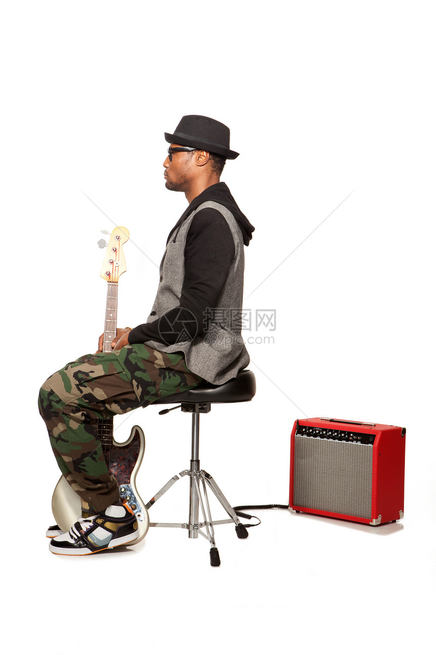 坐在电吉他凳子上的男人图片