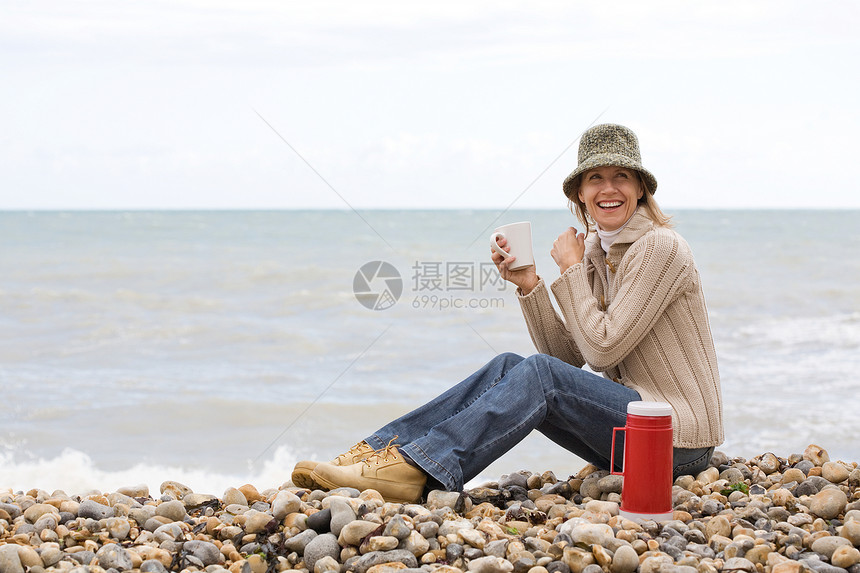 在海滩上喝酒的女人图片