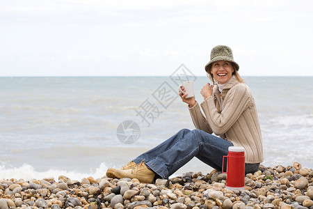 在海滩上喝酒的女人图片