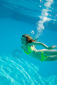 在游泳池里游泳的年轻女子图片
